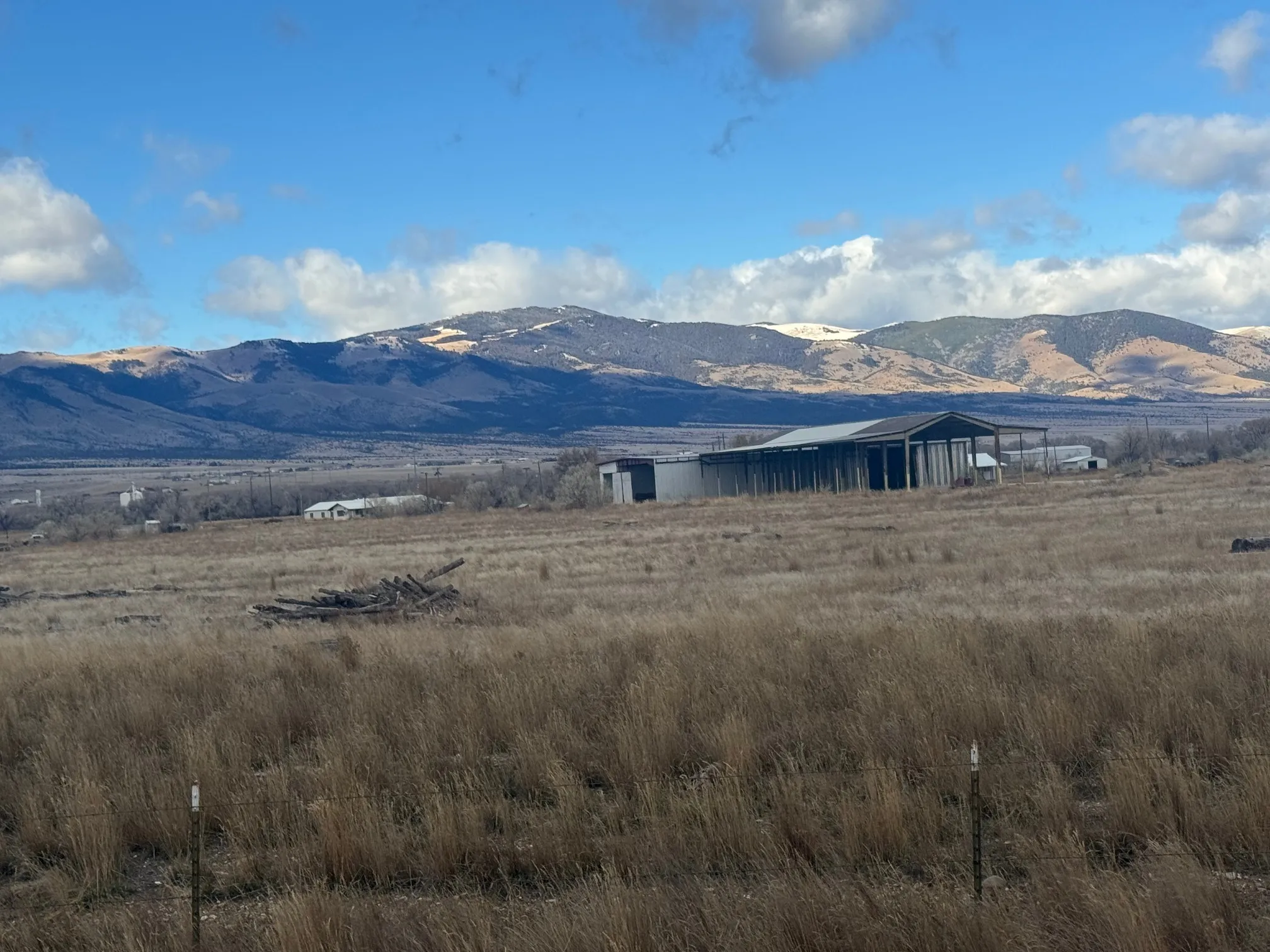Open grassland on the Townsend campus with a steel building and mountains beyond
